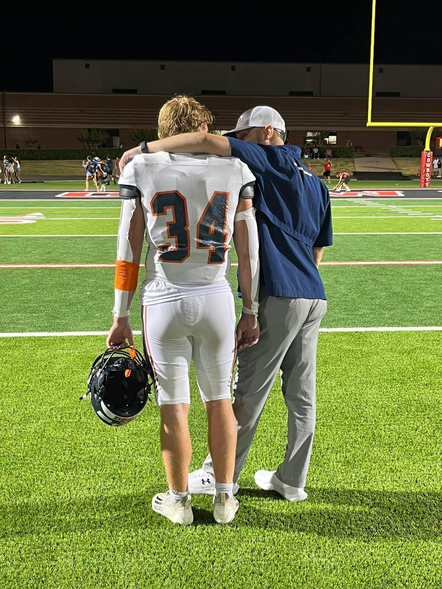Hayden Burnett encouraging a football player on the sideline