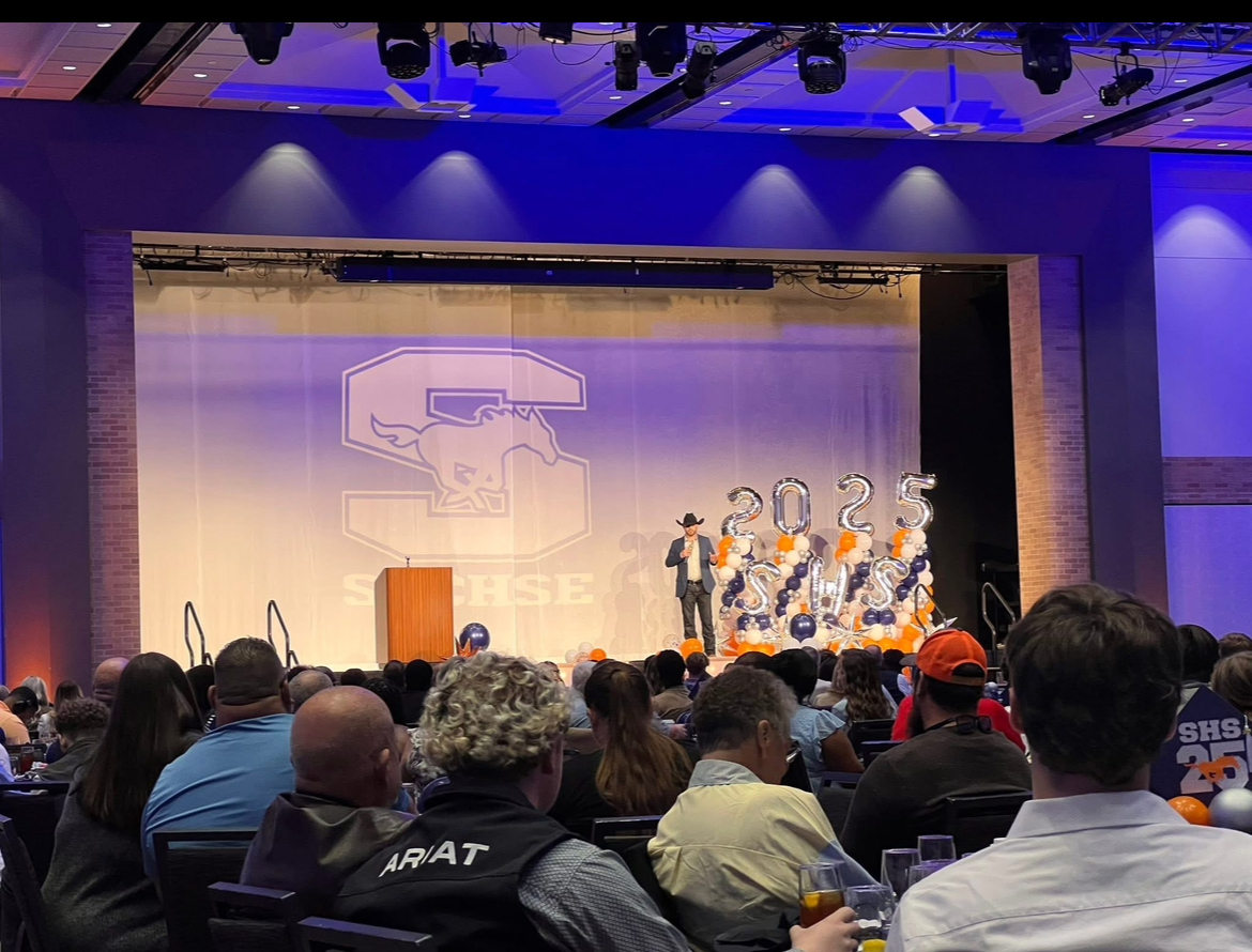 Hayden Burnett speaking to a large audience at the Sachse High School Senior Brunch